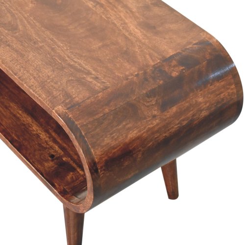 A close-up of the Artisan Furniture Amaya Mango Wood Coffee Table 35 (2 Colors) shows its smooth curved edge, modern Nordic design, solid mango wood tabletop, tapered legs, and convenient lower shelf.
