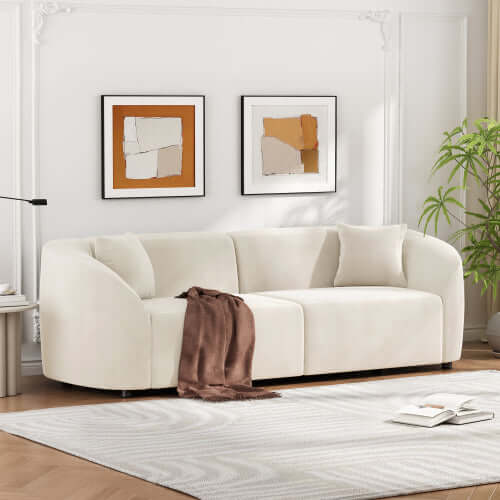 Contemporary sloped arm boucle upholstered sofa in cream with decorative throw and pillows in stylish living room setting.