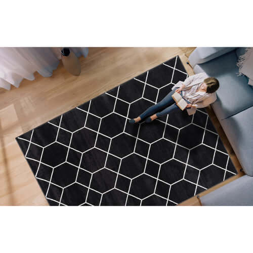 Trellis black and white geometric woven area rug in a modern living room setting.