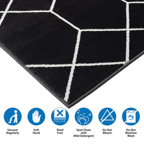 Close-up of Trellis black and white geometric area rug, showcasing soft texture and care instructions.