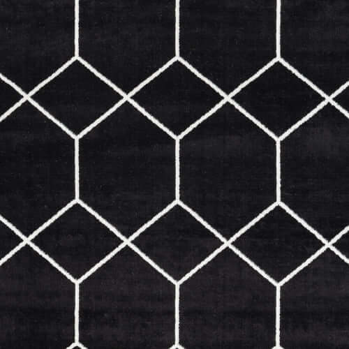 Trellis black and white geometric woven area rug detail, featuring bold diamond pattern and modern design.