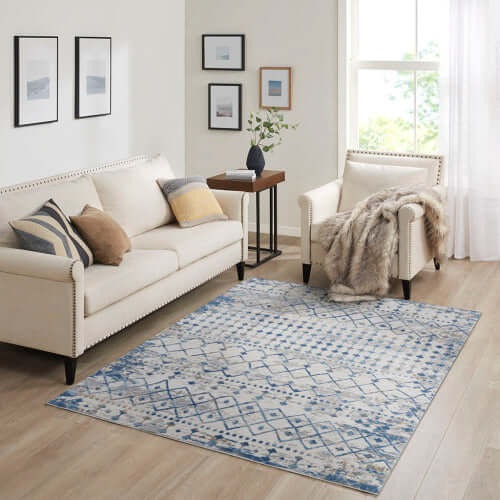 Moroccan styled woven blue and beige area rug in living room with cream sofa and modern decor.