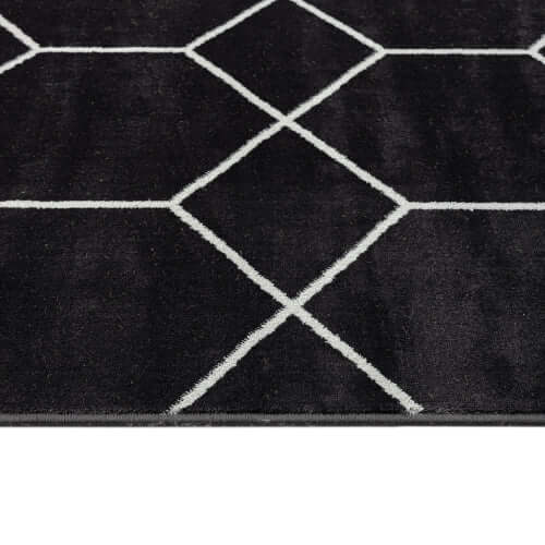 Close-up of Trellis black and white geometric woven area rug showcasing bold trellis pattern and soft texture.