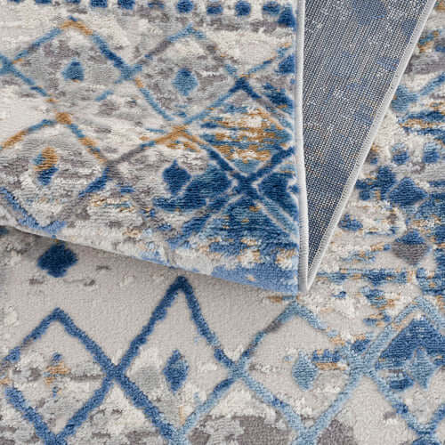 Close-up of a Moroccan styled woven area rug featuring blue and beige tones with a diamond pattern.