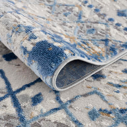 Close-up of Moroccan styled blue and beige area rug showing texture and intricate patterns.