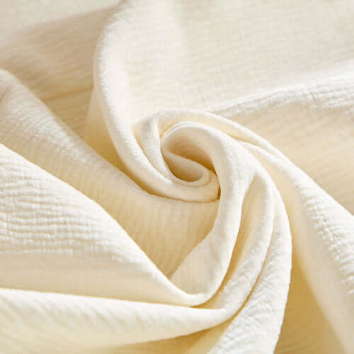 Close-up of cream fabric, showcasing soft texture and subtle sheen, ideal for modern furniture upholstery.