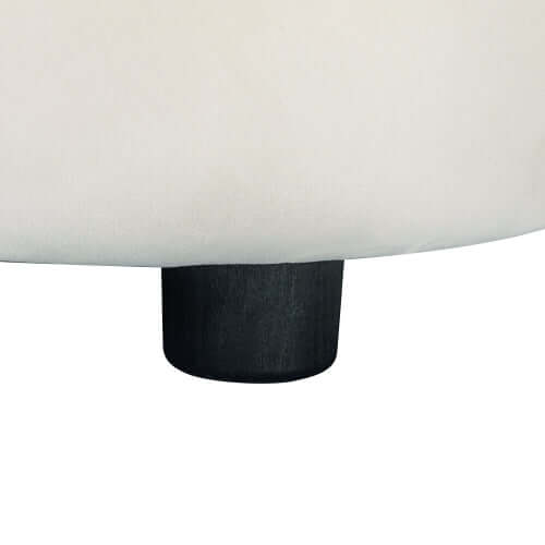 Close-up of the black wooden leg of a contemporary boucle upholstered sofa.