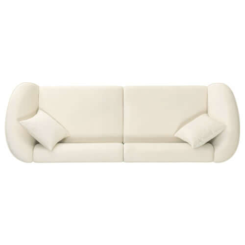 Contemporary sloped arm boucle upholstered sofa in cream with two accent pillows, showcasing bold curves and modern design.