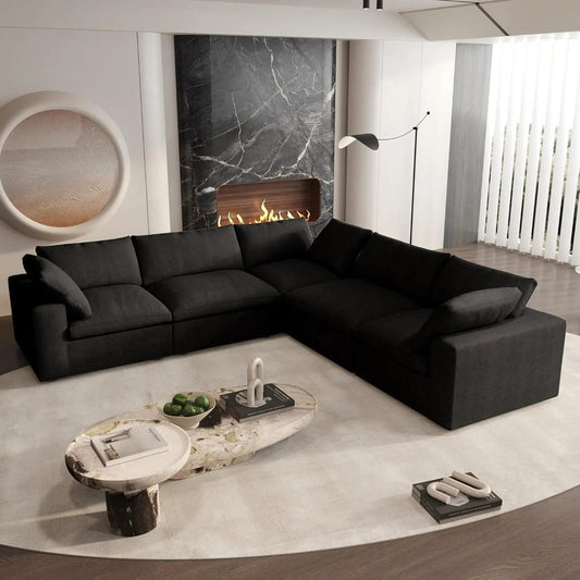 Stylish black modular L shaped sectional in a modern living room with a fireplace and decorative coffee table.