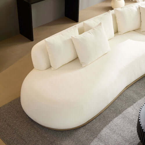 Stylish rounded white L-shaped chaise sofa with plush pillows, perfect for modern living spaces.