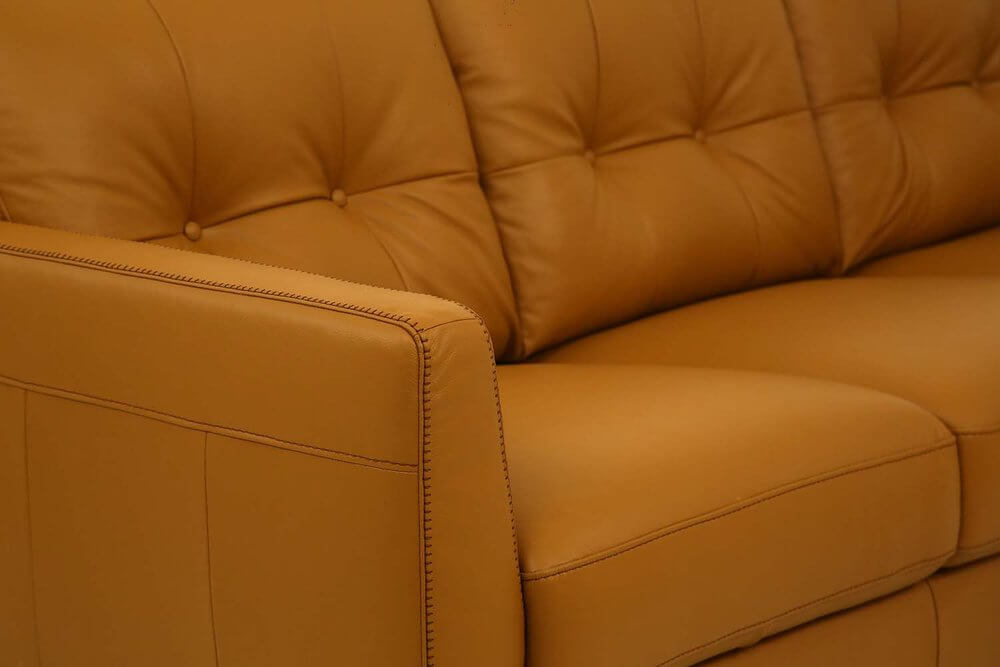 83" Orange Leather Sofa With Black Legs featuring buttery soft leather and elegant stitching detail.