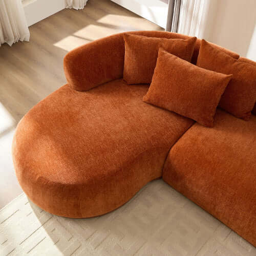 Rounded L-Shaped Chaise Sofa Sectional in bold orange with plush cushions, perfect for modern living spaces.