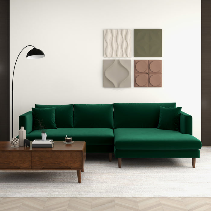 A modern living room features the Ashcroft Furniture Blake Velvet Upholstered L-Shape Chaise Sofa Sectional 107 in green, paired with a wood coffee table, black floor lamp, light rug, and four geometric wall art pieces for a minimalist contemporary vibe.