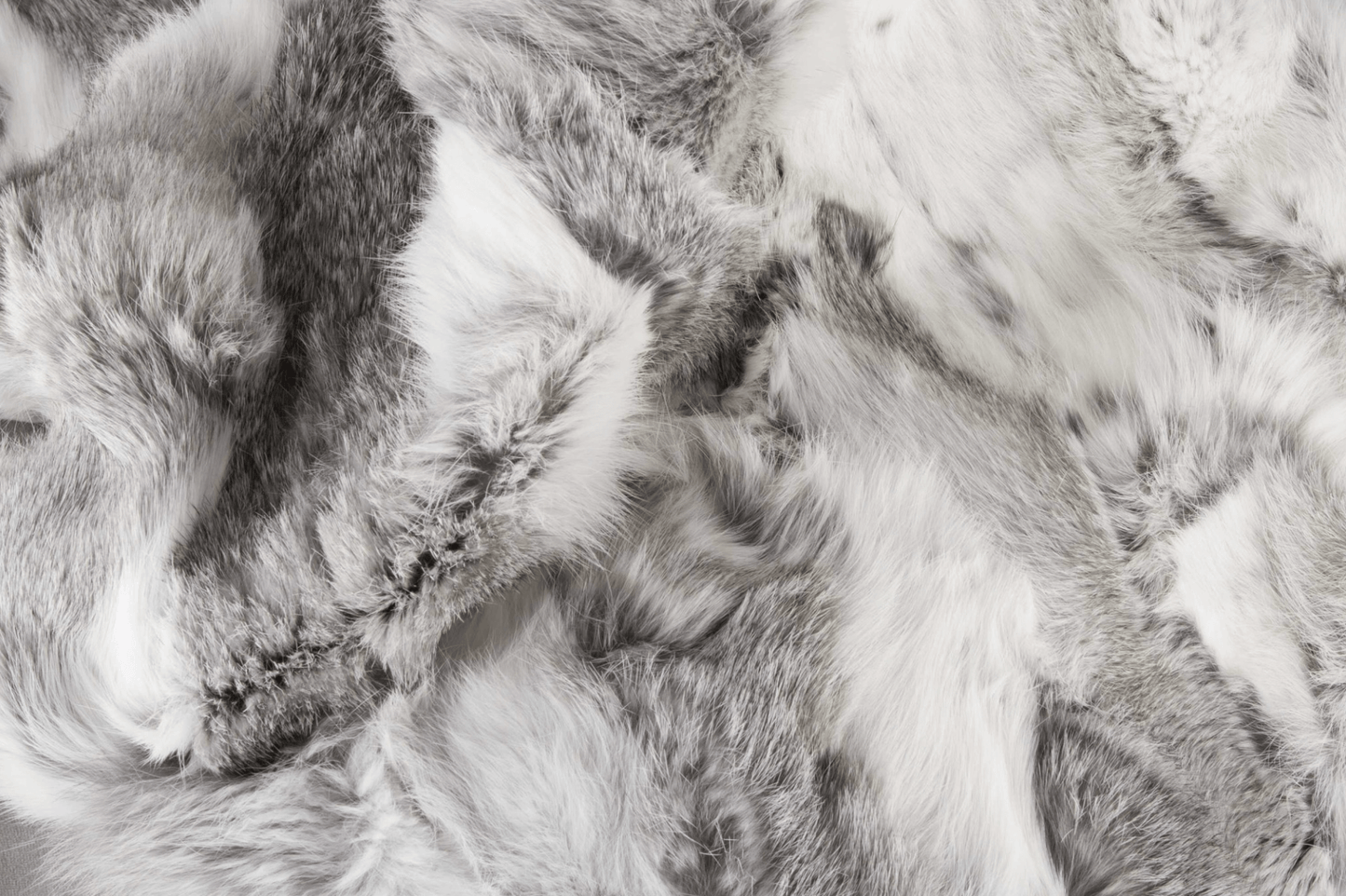 Close-up of the Home Roots Gray Rabbit Fur Throw Blanket, showcasing its genuine rabbit fur in white, gray, and black tones with chic knitted patterns and soft textured surface.