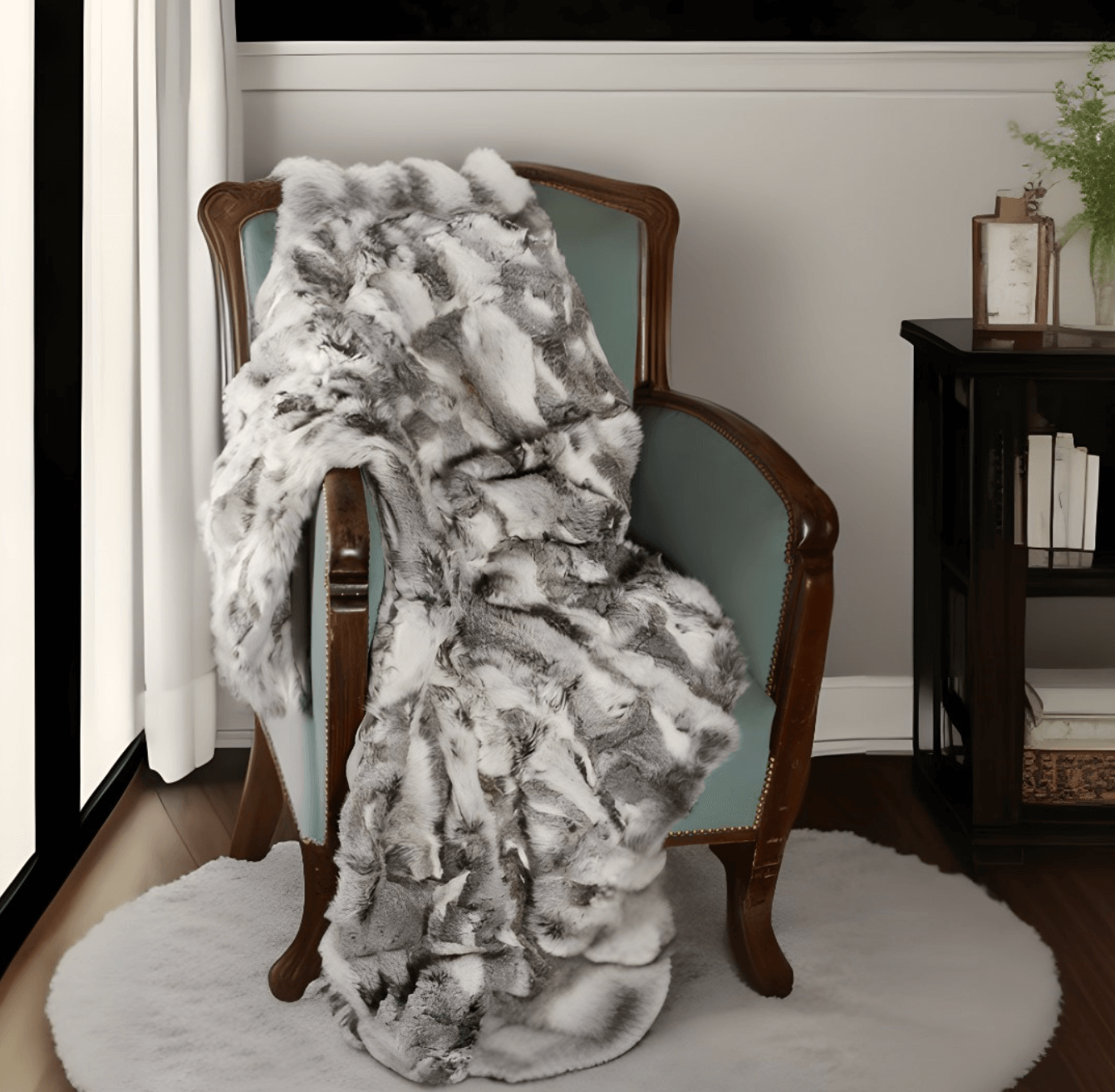 A wooden armchair with light blue upholstery is draped with the Home Roots Gray Rabbit Fur Throw Blanket in a chic knitted design. The chair stands on a round white rug next to a black bookshelf holding books and a small plant.