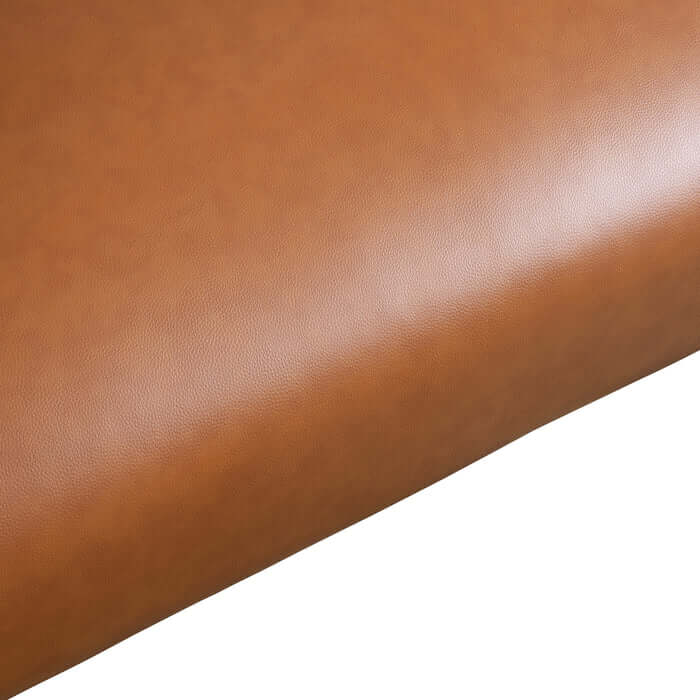 Cognac brown PU leather fabric close-up, showcasing texture and color for mid-century modern furniture.