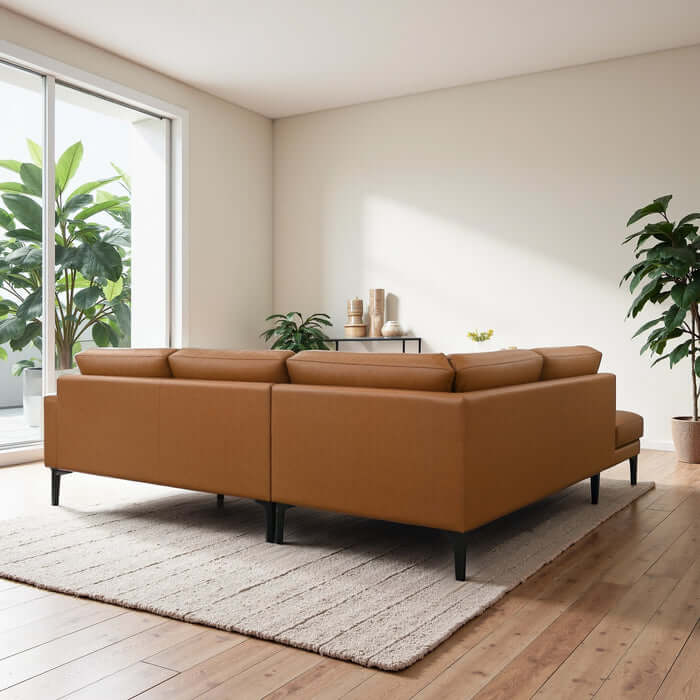 Bristol Vegan Leather Left-Facing Chaise Sofa Sectional in a cozy living room setting with plants.