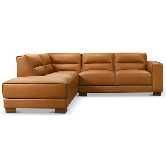The Ashcroft Furniture Co. Muncie MCM L-Shaped Left-Facing Chaise Sofa Sectional 98W is upholstered in light brown vegan leather with wide armrests, tufted back cushions, and block-style feet, shown on a plain white background.