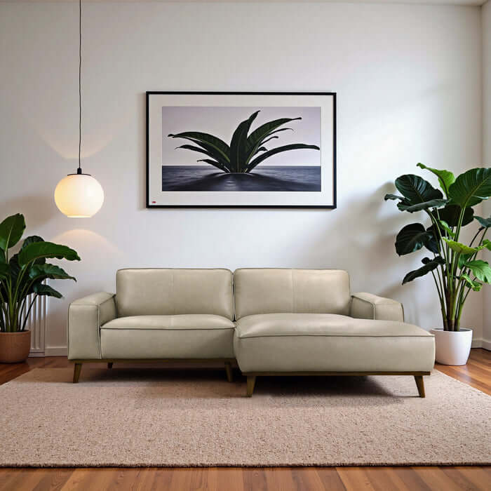 Kerrville beige leather right-facing chaise longue sofa sectional in modern living room with plants and artwork.