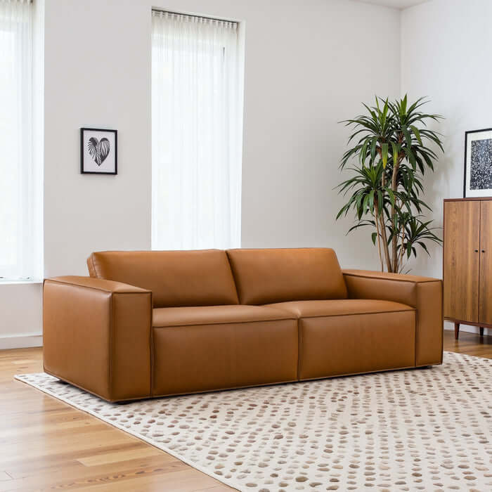 Uvalde MCM Vegan Leather Wide-Arm Sofa in rich cognac color in modern living room setting.