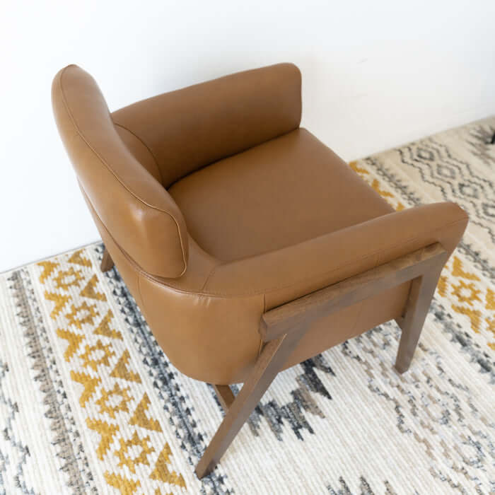 Kayson MCM Tan Leather Lounge Chair on a patterned rug, showcasing mid-century modern design and luxurious comfort.
