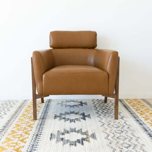 Kayson MCM tan leather lounge chair on a stylish patterned rug, perfect for mid-century modern decor.