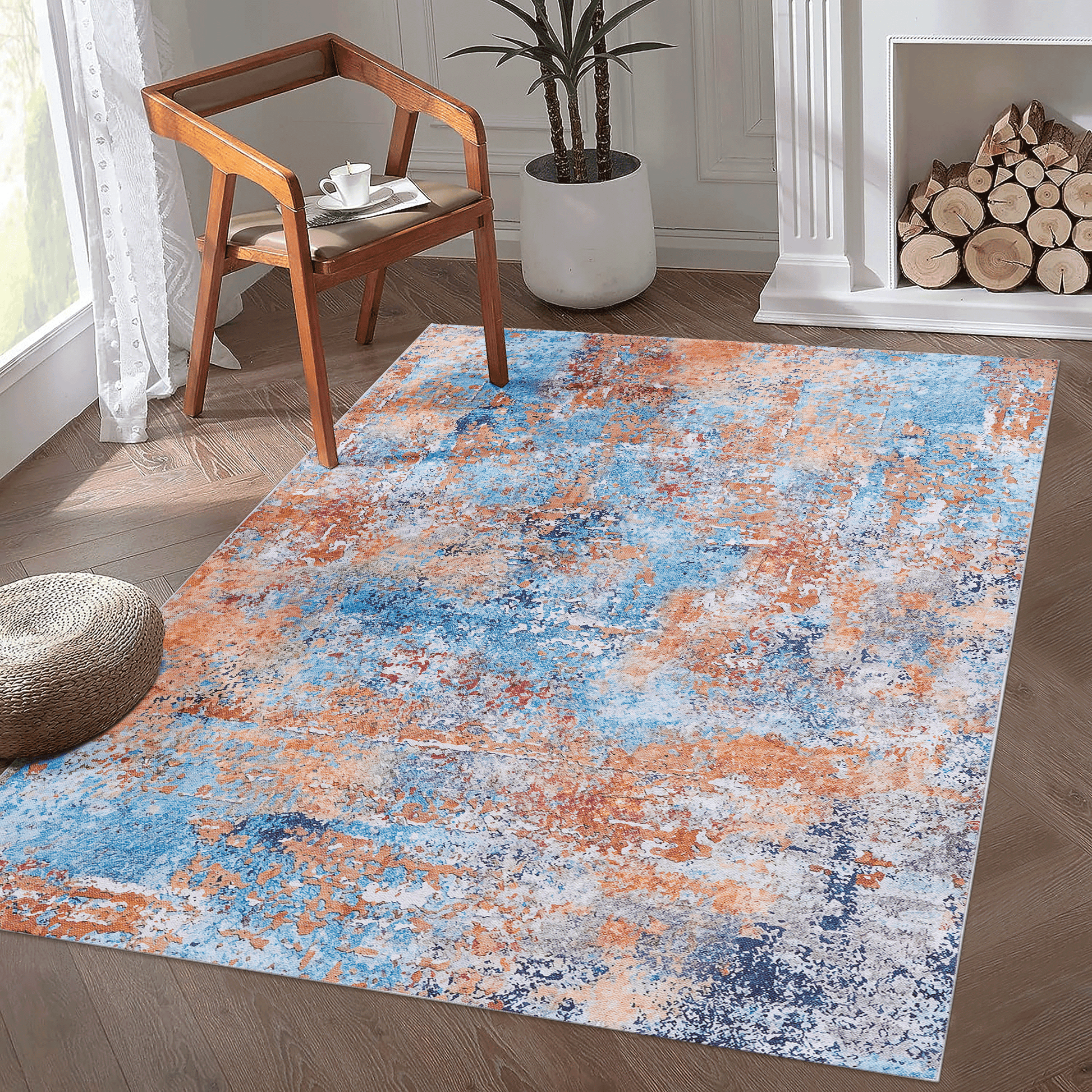 Multi-colored abstract washable area accent rug with blue and orange patterns in a modern living room setting.
