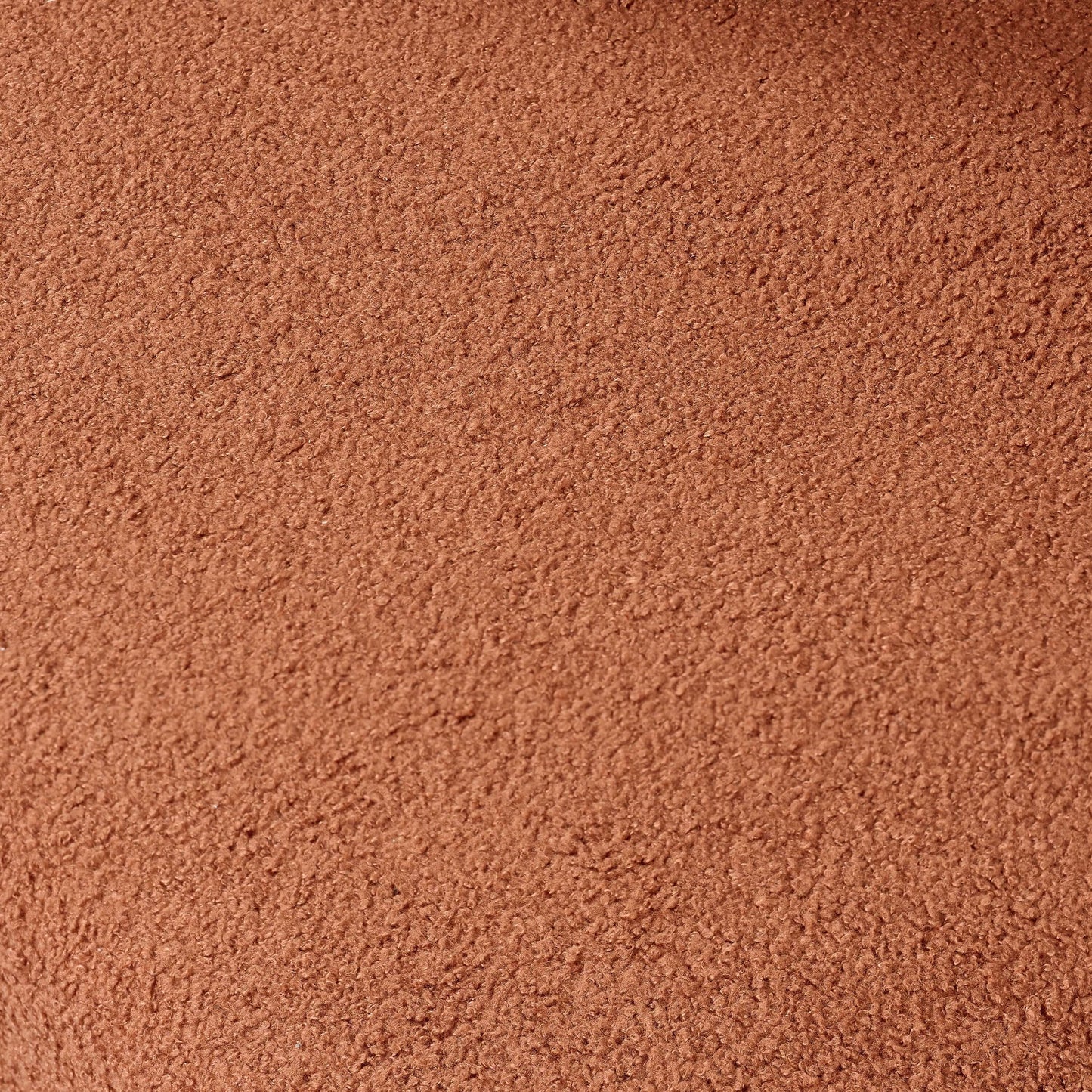 Close-up view of soft, textured rust-colored bouclé fabric for upholstery.