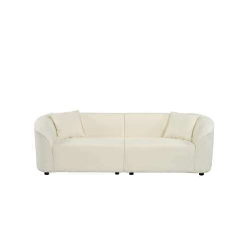 Contemporary sloped arm boucle upholstered sofa in cream color, featuring bold curves and luxurious comfort.