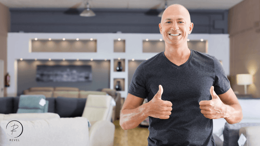 Smiling man giving thumbs up in a modern furniture store, promoting online furniture shopping.
