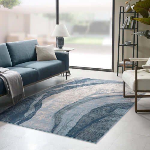 Blue abstract wave area rug in modern living room, featuring fluid patterns and available in two sizes.