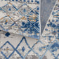 Close-up of a Moroccan styled woven area rug featuring blue and beige tones with a diamond pattern.