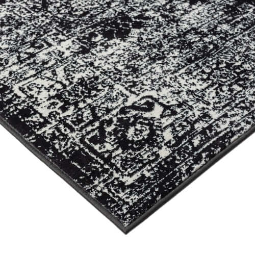Close-up of distressed vintage Persian styled woven area rug showcasing intricate pattern and texture.