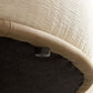 Close-up of the underside of a chaise sofa, showcasing the soft cream fabric and protective base.