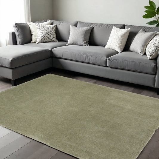 Sage Hand Woven Area Rug | 9' x 13' on hardwood floor, complementing modern gray sectional sofa with decorative pillows.
