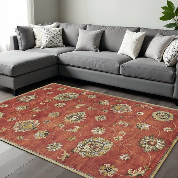 Sienna Gold And Green Wool Floral Vines Hand Tufted Area Rug | 9' x 13' displayed in a living room with a gray couch.