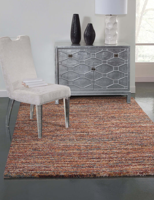 Zira multicolor rectangular area rug in modern living space with chair and decorative furniture.