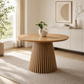 47-Inch Modern Round Dining Table for 4 with natural wood finish and slatted base in a bright dining room.
