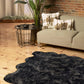 Scalloped faux fur shag rug in a modern living room setting, paired with decorative pillows and plants.