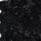 Close-up of soft black faux fur shag rug, showcasing plush texture and scalloped design ideal for modern decor.
