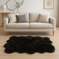 Scalloped faux fur shag rug in black under a modern sofa for stylish home decor.