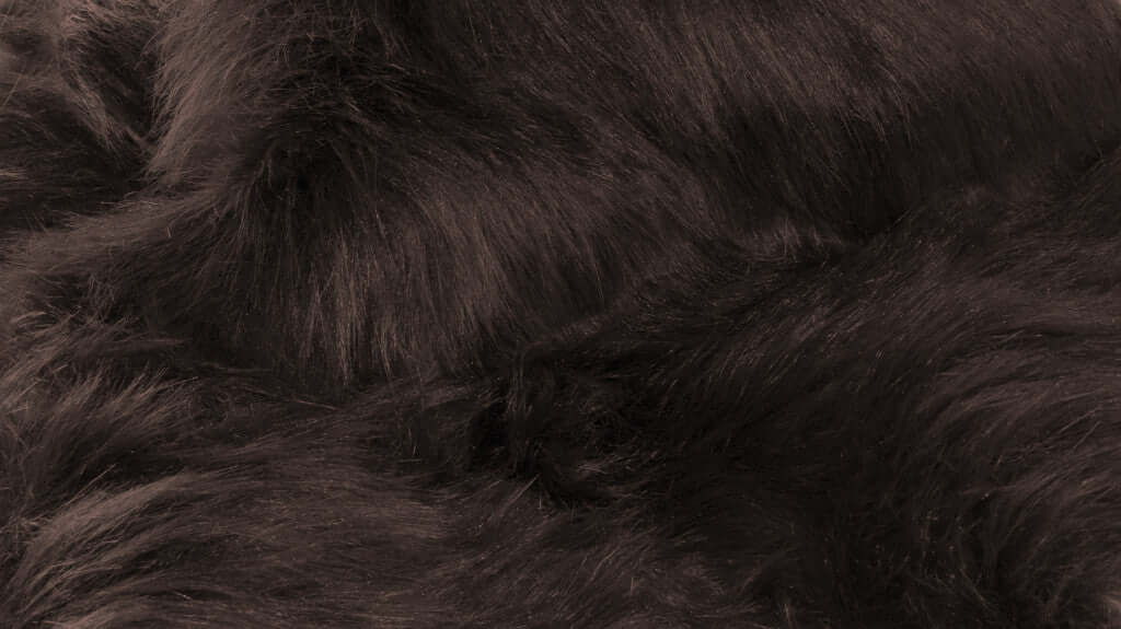 Close-up of soft, luxurious dark faux fur, showcasing the plush texture of a sleek shag rug.
