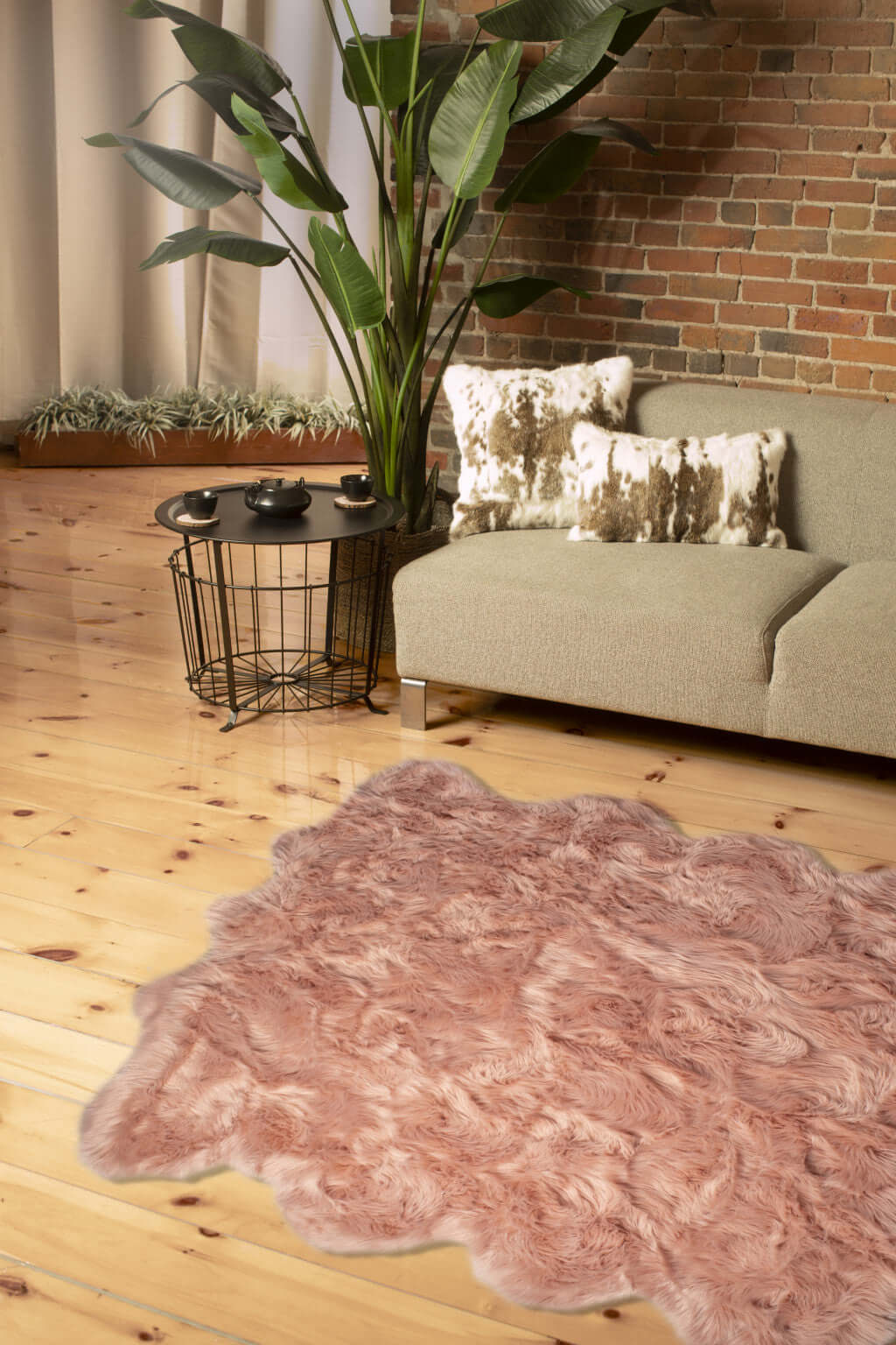 Scalloped faux fur shag rug in soft pink, enhancing a modern living room with stylish decor and cozy elegance.