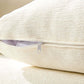 Close-up of soft cream pillow with zipper detail, showcasing its plush texture and quality design.