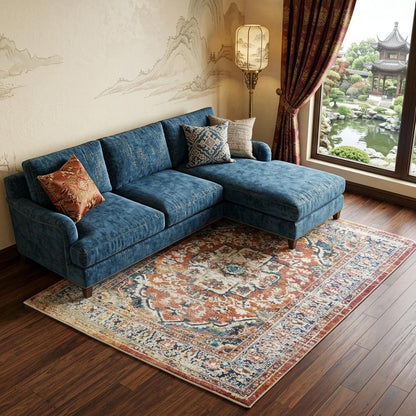 Rust Oriental Distressed Area Rug With Fringe Area Rug | 9' x 13' featured under blue sectional sofa in a stylish room.