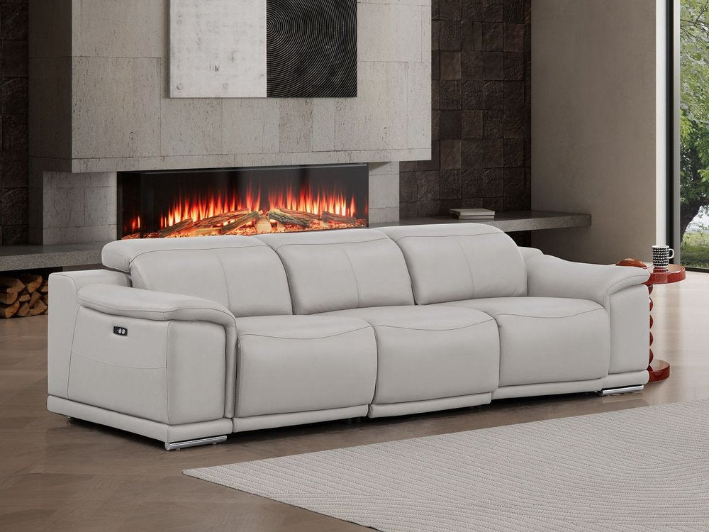107" Light Gray Top Grain Leather Reclining USB Sofa in a modern living room setting with a cozy fireplace.