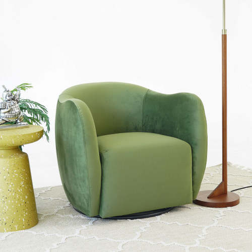 Swivel Lounge Chair in Green Velvet – Renee Modern Barrel Accent Chair next to a side table and lamp in a stylish setting.