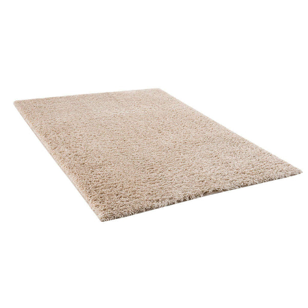 Super soft rectangular beige polyester shag area rug, perfect for cozy living rooms or bedrooms.