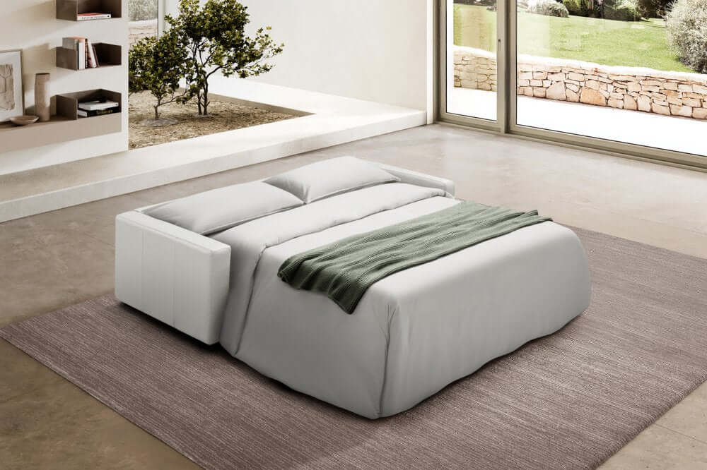 81" White Leather Sleeper Sofa in modern living room with contemporary decor and soft bedding.