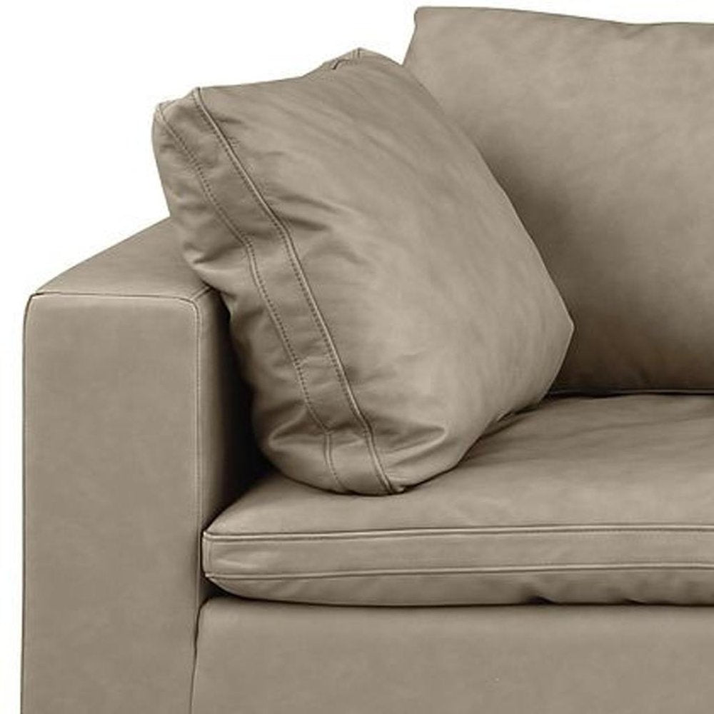 Close-up of the 122" Beige Top Grain Leather Reclining Solid Wood Sofa with a plush pillow.